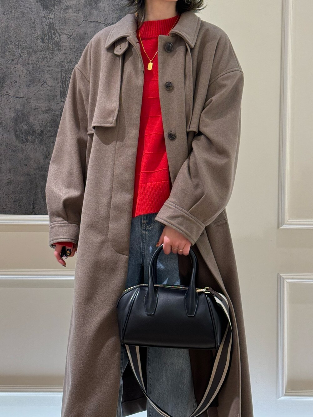 ブルー系のデニムパンツ、ブラック系のブーツ、ブラウン系のステンカラーコートを着用したレディースの冬コーディネートの4枚目の写真