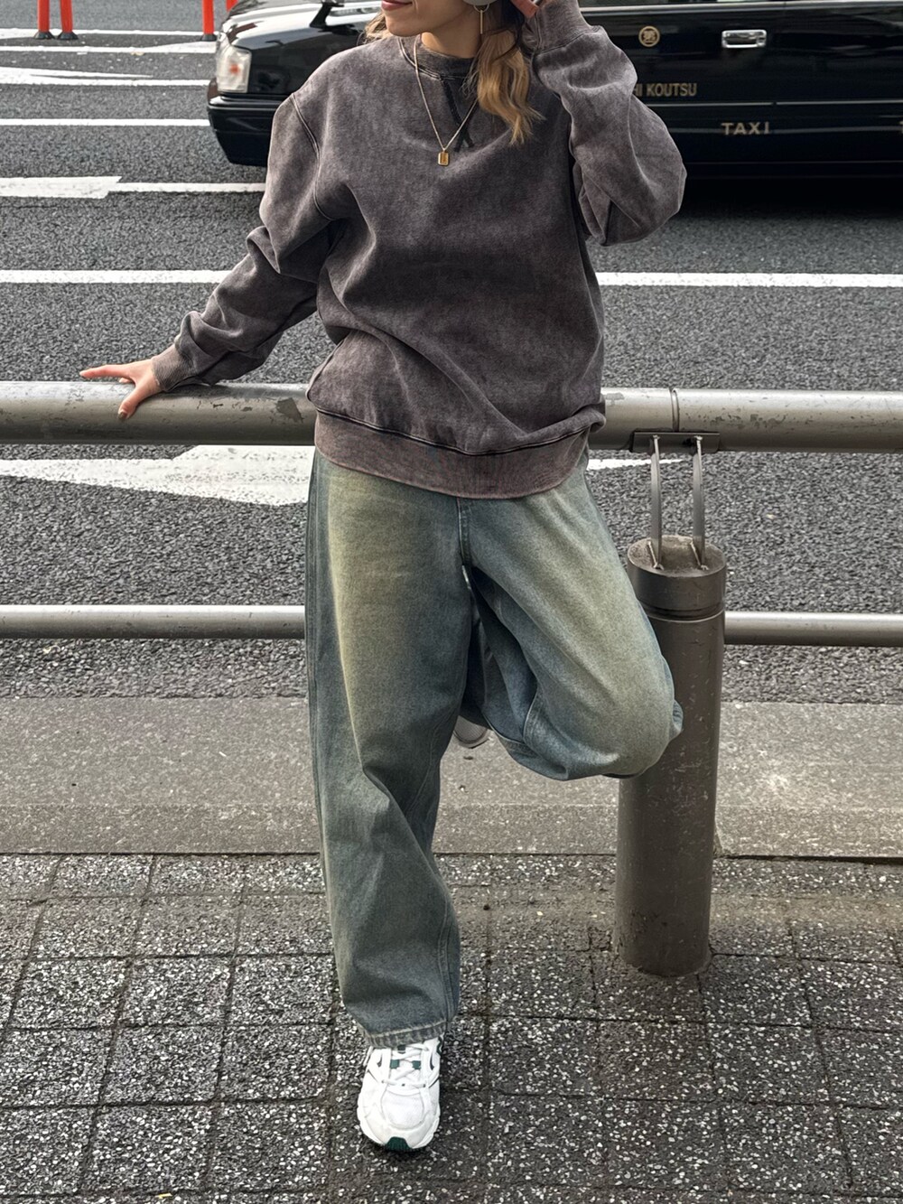 ブラック系のスウェット、ブルー系のデニムパンツを着用したレディースの冬コーディネートの4枚目の写真