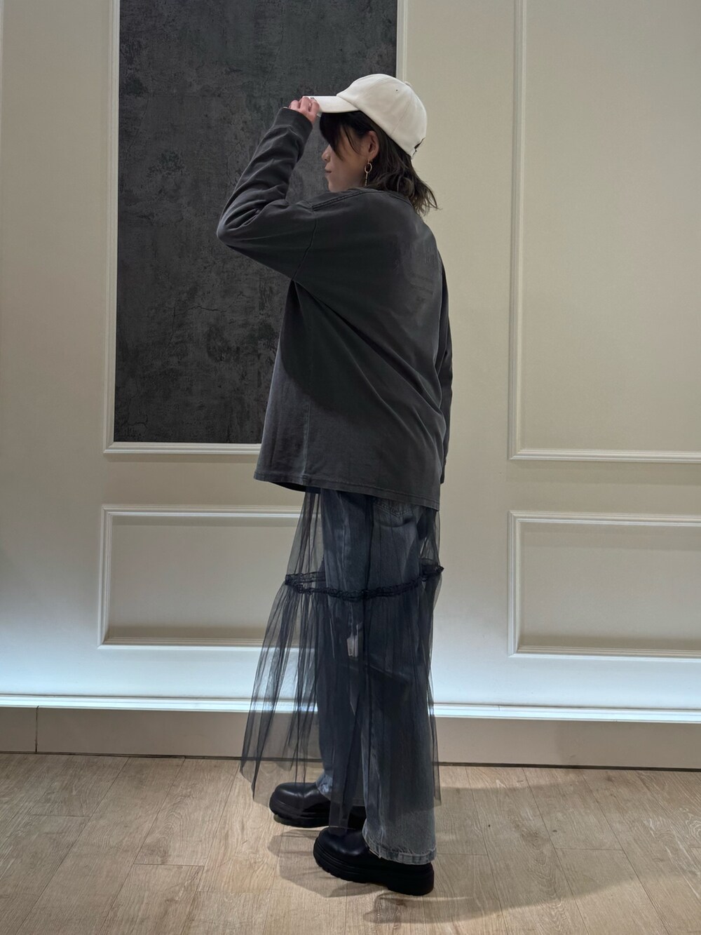 グレー系のTシャツ/カットソー、グレー系のスカート、ブルー系のデニムパンツを着用したレディースの冬コーディネートの3枚目の写真