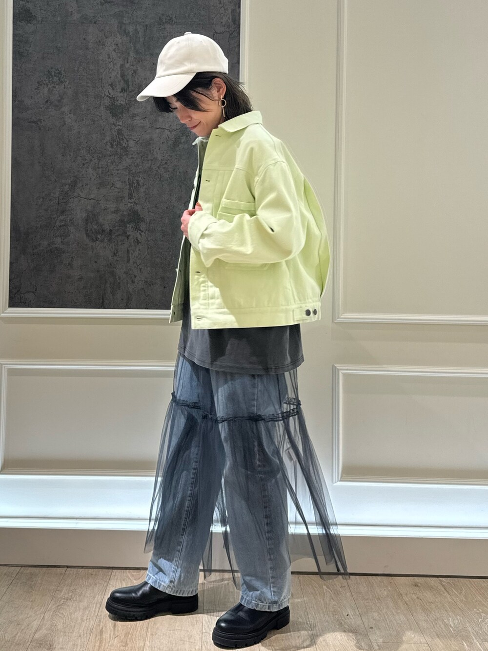 グリーン系のデニムジャケット、グレー系のTシャツ/カットソー、グレー系のスカートを着用したレディースの冬コーディネートの2枚目の写真