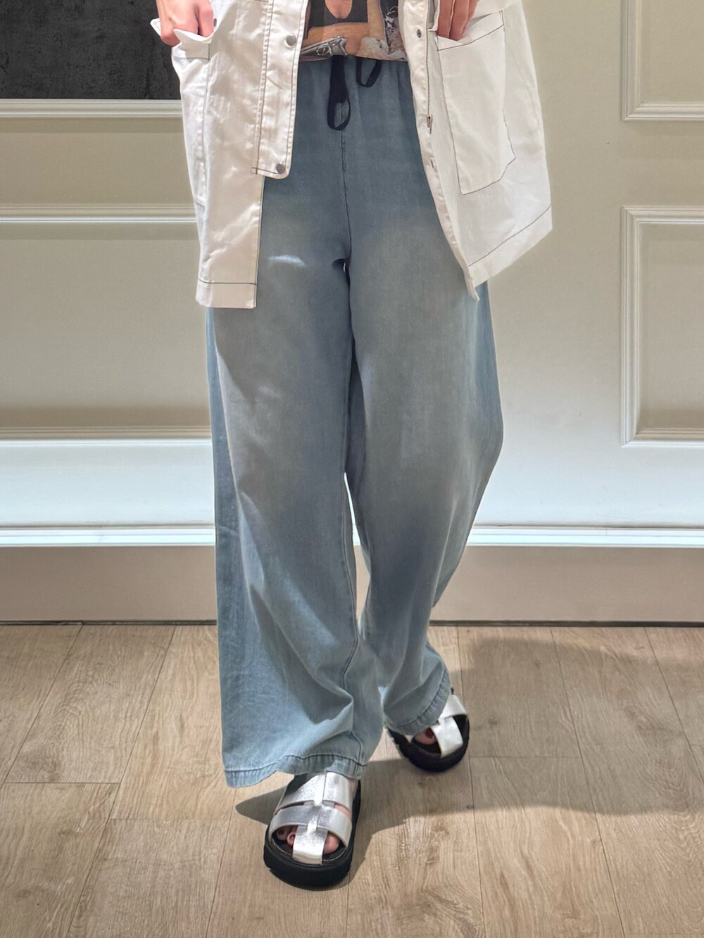 ホワイト系のベスト、ブラック系のTシャツ/カットソー、ブルー系のデニムパンツを着用したレディースの夏コーディネートの3枚目の写真