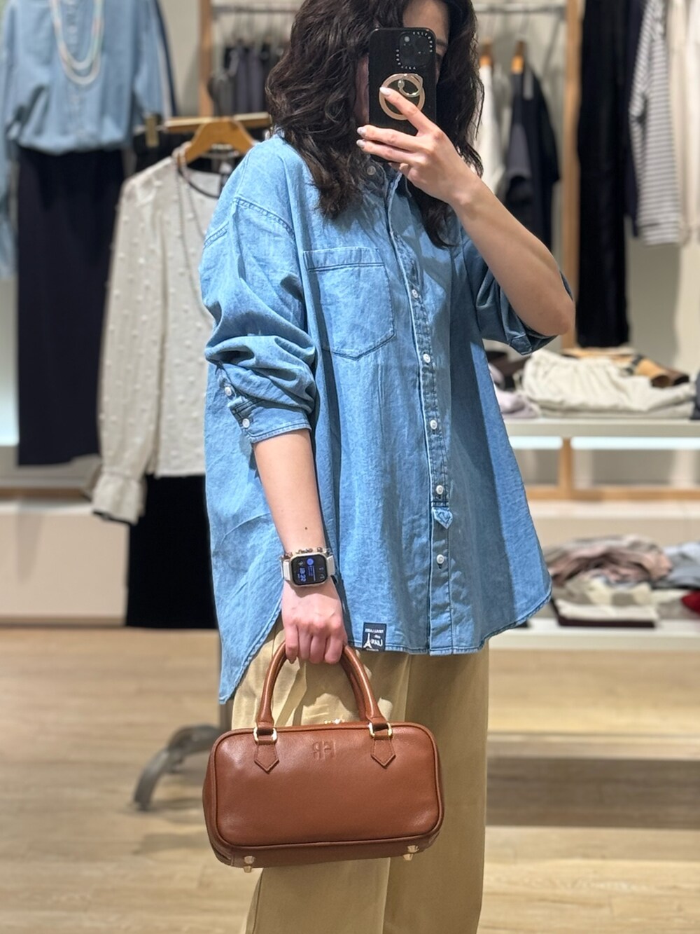 ブルー系のシャツ/ブラウス、ベージュ系のチノパンツ、イエロー系のショルダーバッグを着用したレディースの春コーディネートの3枚目の写真