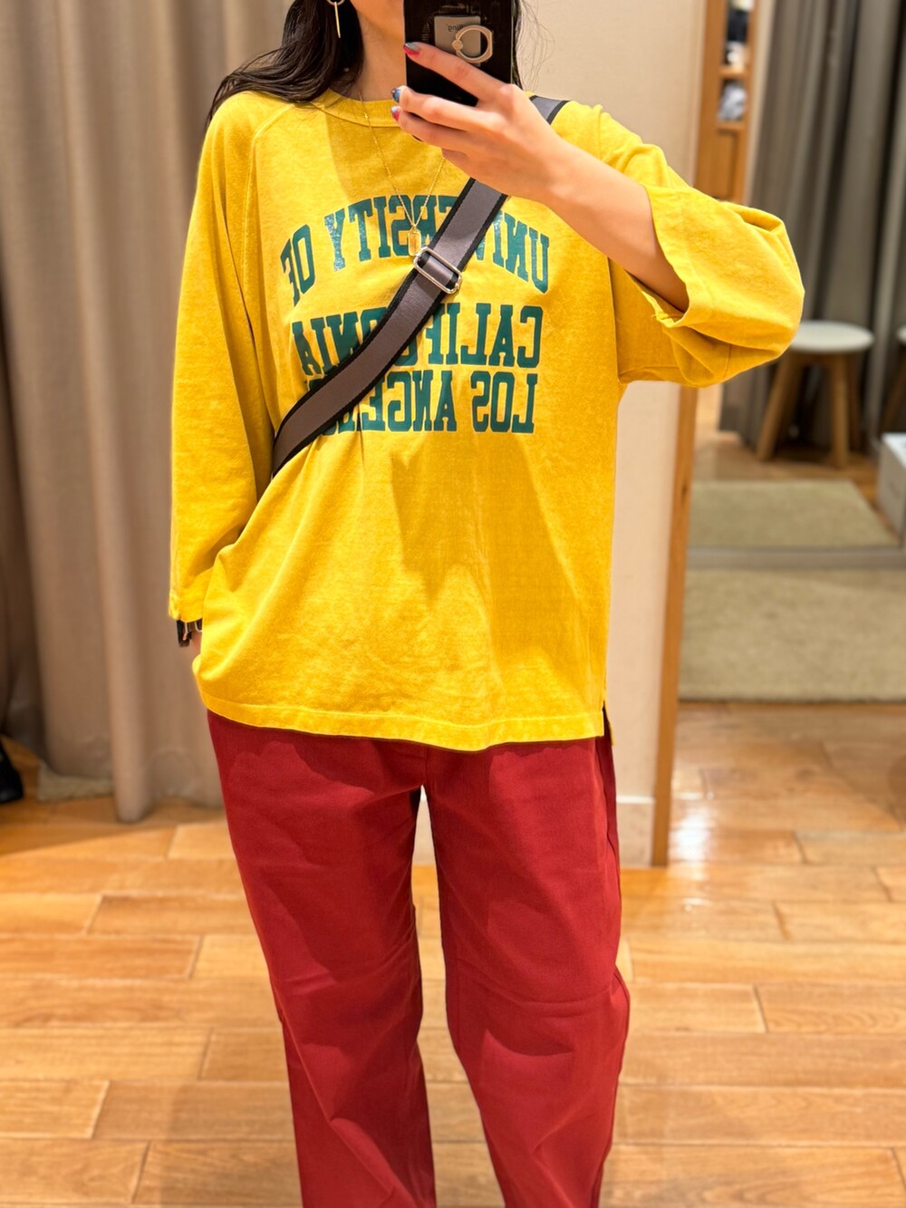 イエロー系のTシャツ/カットソー、レッド系のその他パンツ、グレー系のショルダーバッグを着用したレディースの秋コーディネートの2枚目の写真