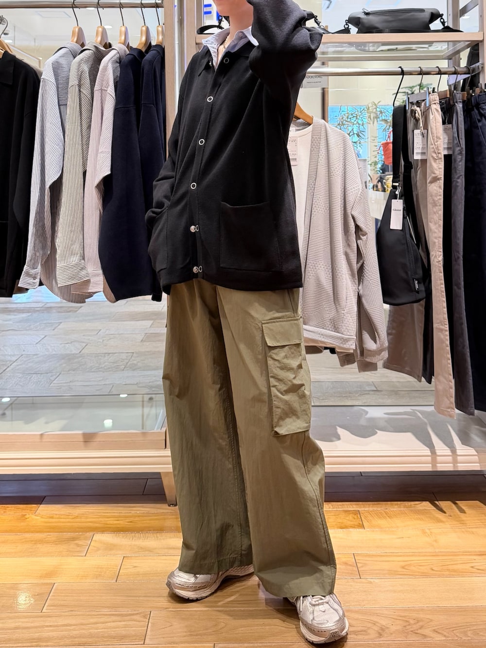 ブラック系のカーディガン/ボレロ、ブルー系のシャツ/ブラウス、グリーン系のカーゴパンツを着用したレディースの春コーディネートの2枚目の写真