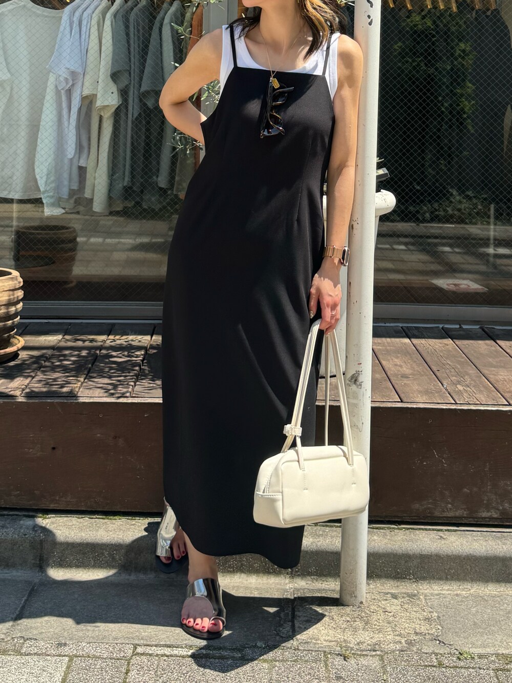 ブラック系のワンピース、ホワイト系のボストンバッグ、シルバー系のサンダルを着用したレディースの夏コーディネートの5枚目の写真