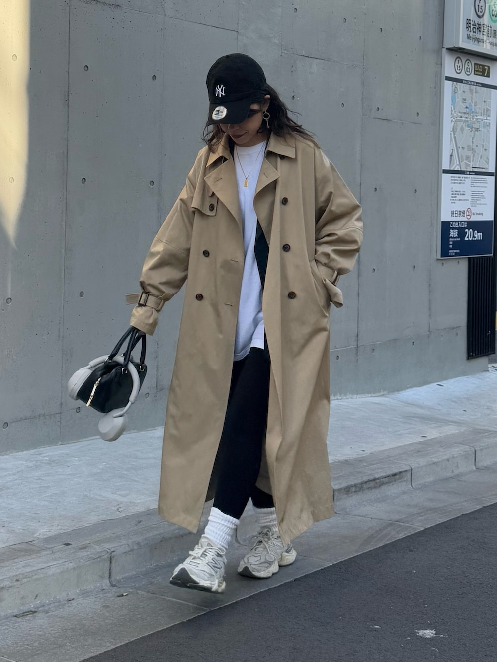 ベージュ系のトレンチコート、ブラック系のハンドバッグを着用したレディースの冬コーディネートの4枚目の写真