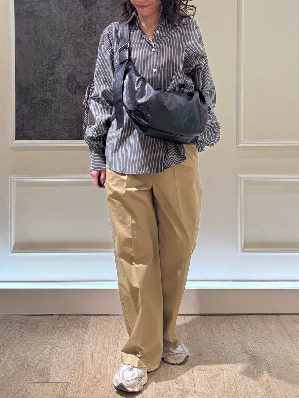 ブルー系のシャツ/ブラウス、ブラウン系のショルダーバッグ、ベージュ系のチノパンツを着用したレディースの冬コーディネートの3枚目の写真
