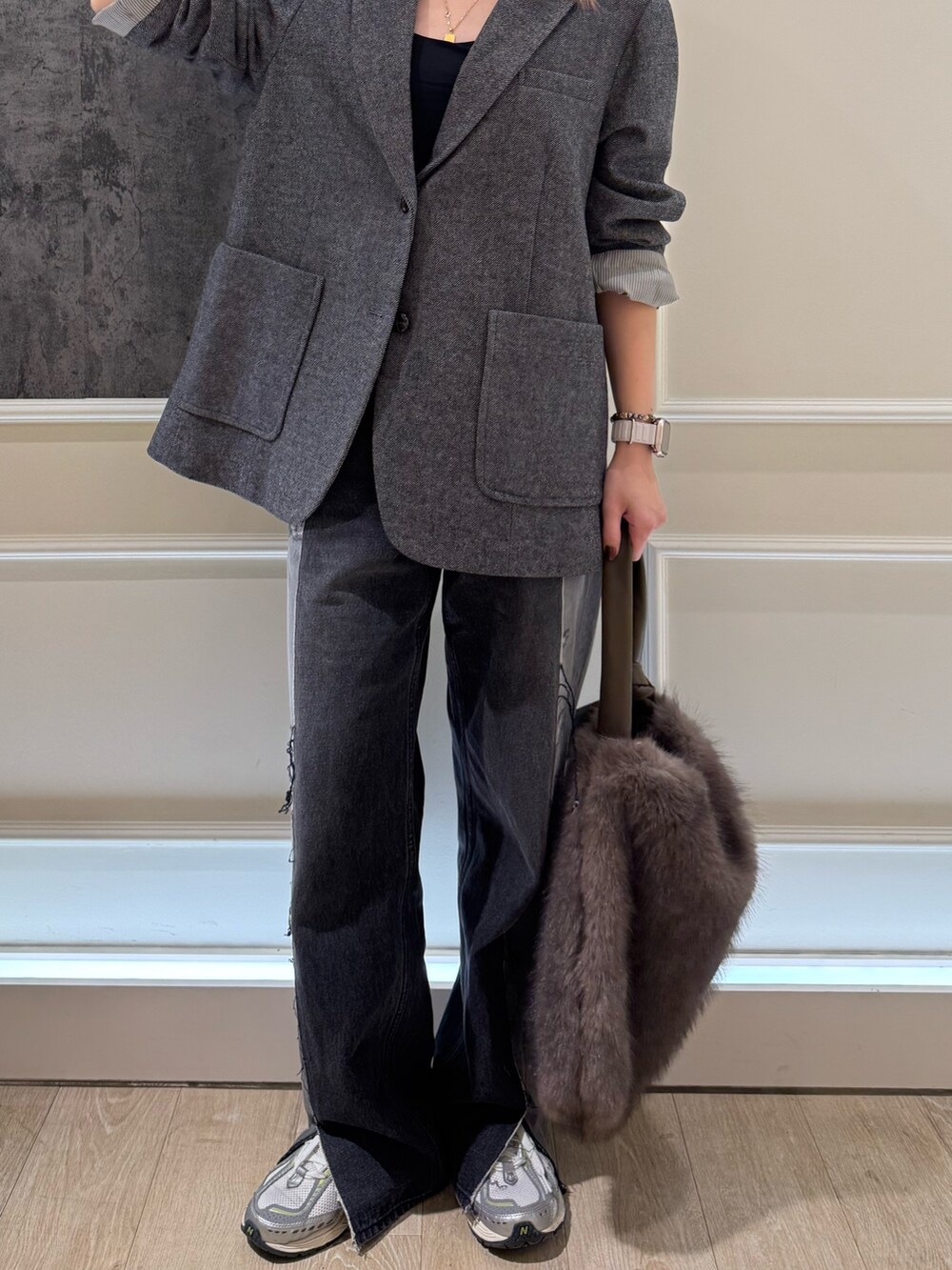 グレー系のテーラードジャケット、ベージュ系のハンドバッグ、ブルー系のキャップを着用したレディースの秋コーディネートの3枚目の写真