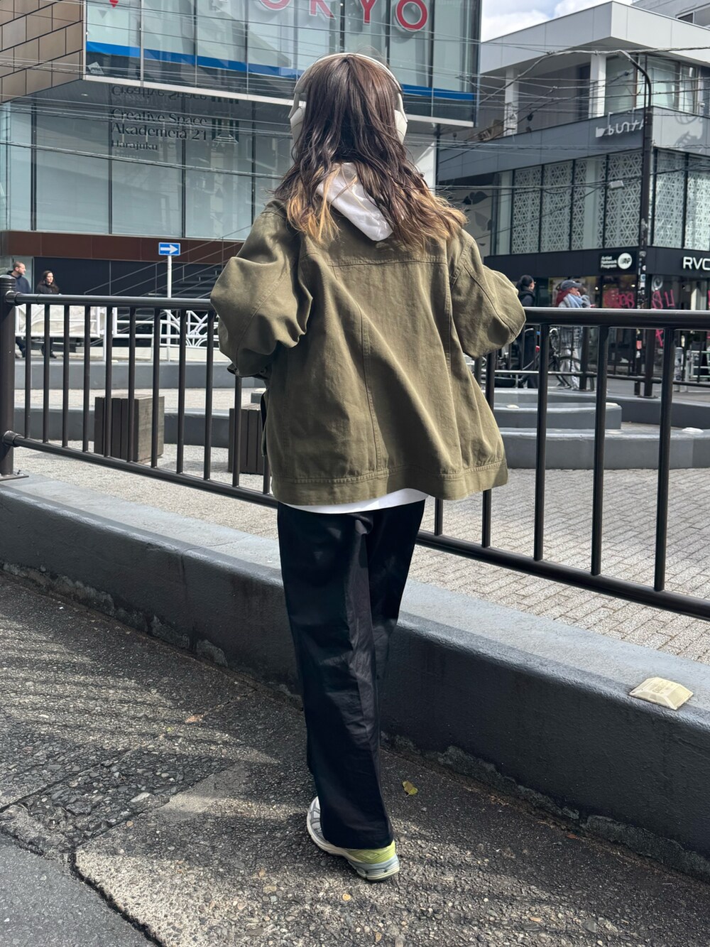 グリーン系のブルゾン、ホワイト系のパーカー、ベージュ系のチノパンツを着用したレディースの春コーディネートの5枚目の写真