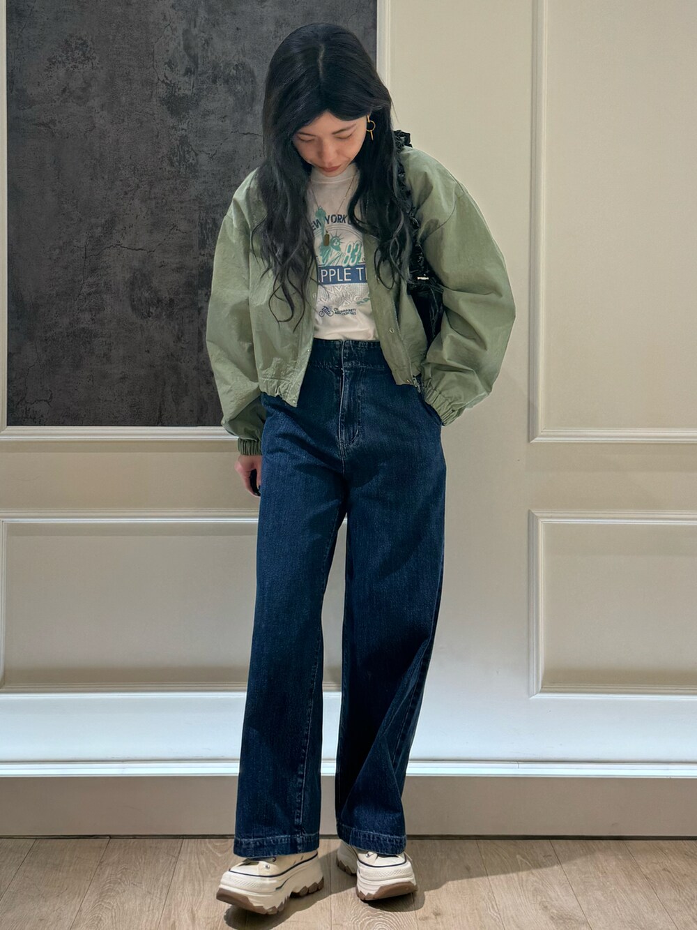 グリーン系のブルゾン、ブルー系のデニムパンツ、ホワイト系のTシャツ/カットソーを着用したレディースの春コーディネートの4枚目の写真