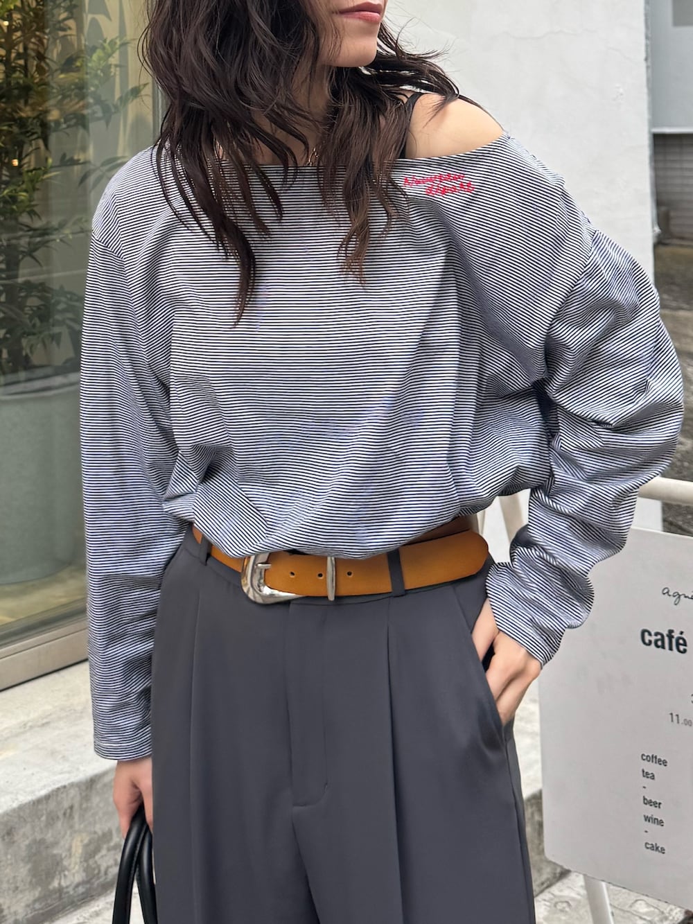 ホワイト系のTシャツ/カットソー、ブラック系のスラックスを着用したレディースの春コーディネートの2枚目の写真