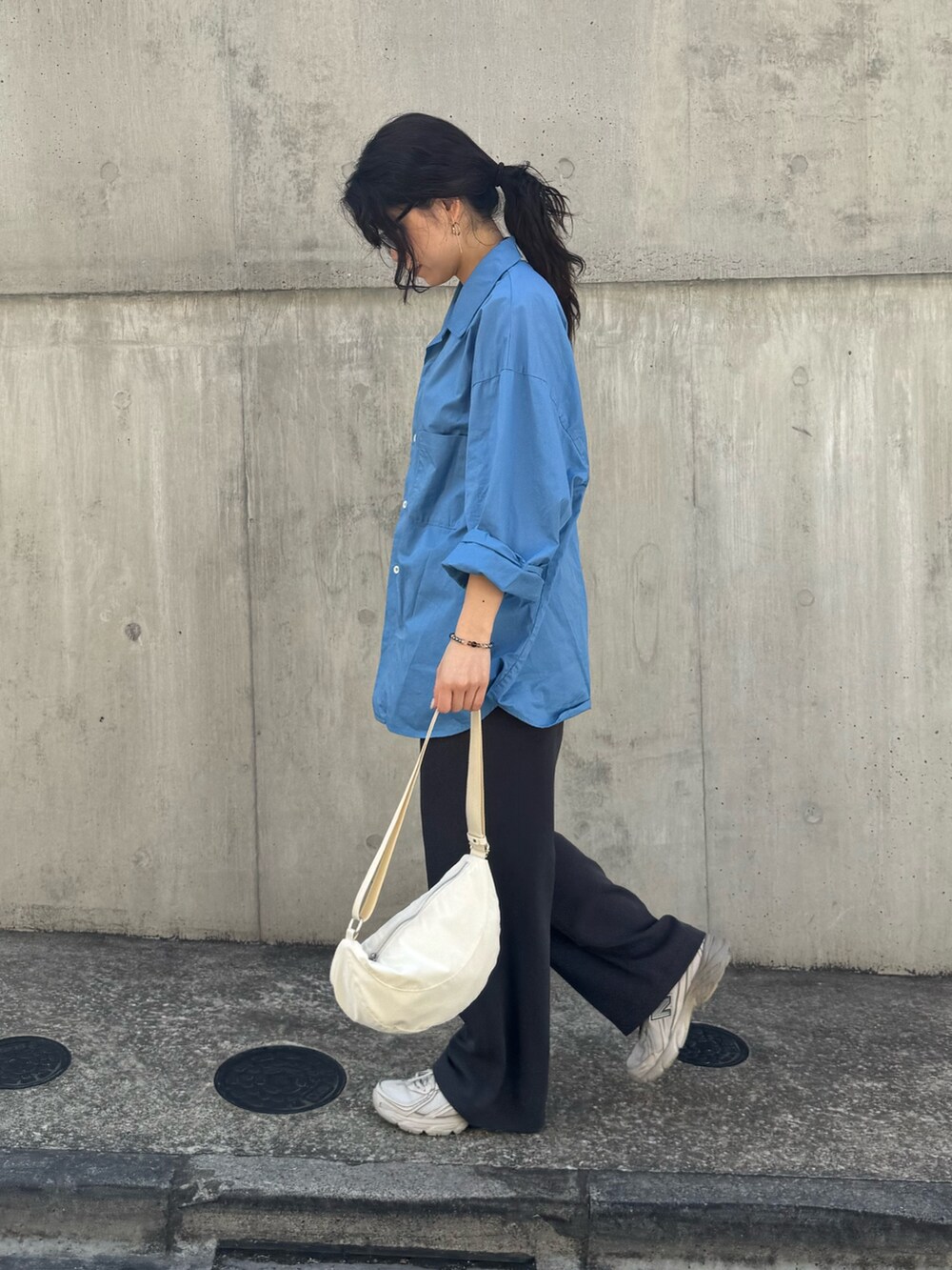 ブルー系のシャツ/ブラウス、グレー系のスラックス、ホワイト系のショルダーバッグを着用したレディースの春コーディネートの6枚目の写真