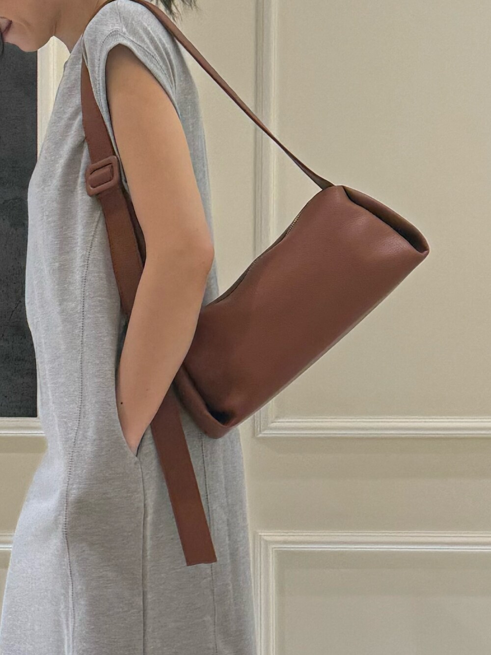 グレー系のワンピース、イエロー系のショルダーバッグ、シルバー系のサンダルを着用したレディースの夏コーディネートの4枚目の写真