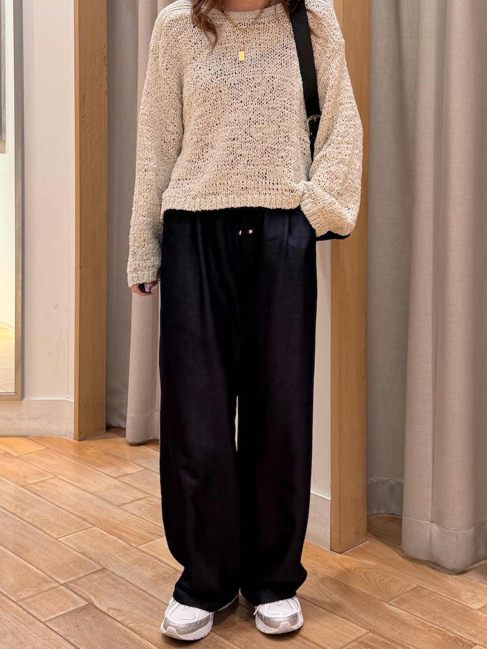 ピンク系のニット/セーター、ブラック系のショルダーバッグ、ブルー系のその他パンツを着用したレディースの春コーディネートの4枚目の写真