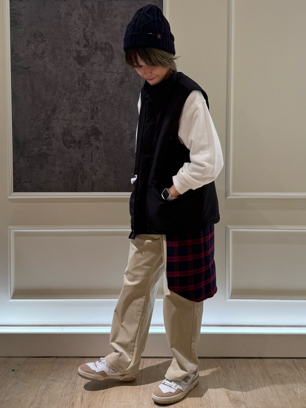 ブラック系のベスト、ホワイト系のスウェット、ブラック系のその他パンツを着用したレディースの秋コーディネートの2枚目の写真
