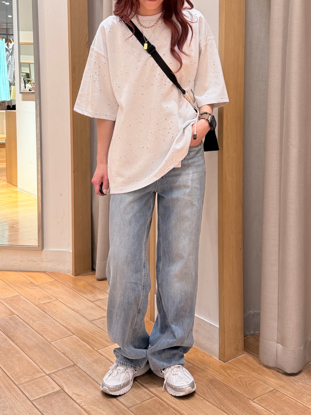 ホワイト系のTシャツ/カットソー、ブルー系のデニムパンツ、ブラック系のショルダーバッグを着用したレディースの春コーディネートの3枚目の写真
