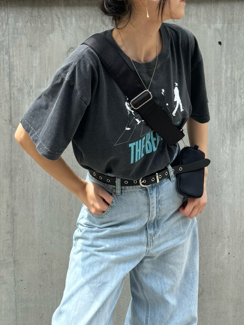 グレー系のTシャツ/カットソー、ブルー系のデニムパンツ、ブラック系のショルダーバッグを着用したレディースの夏コーディネートの4枚目の写真