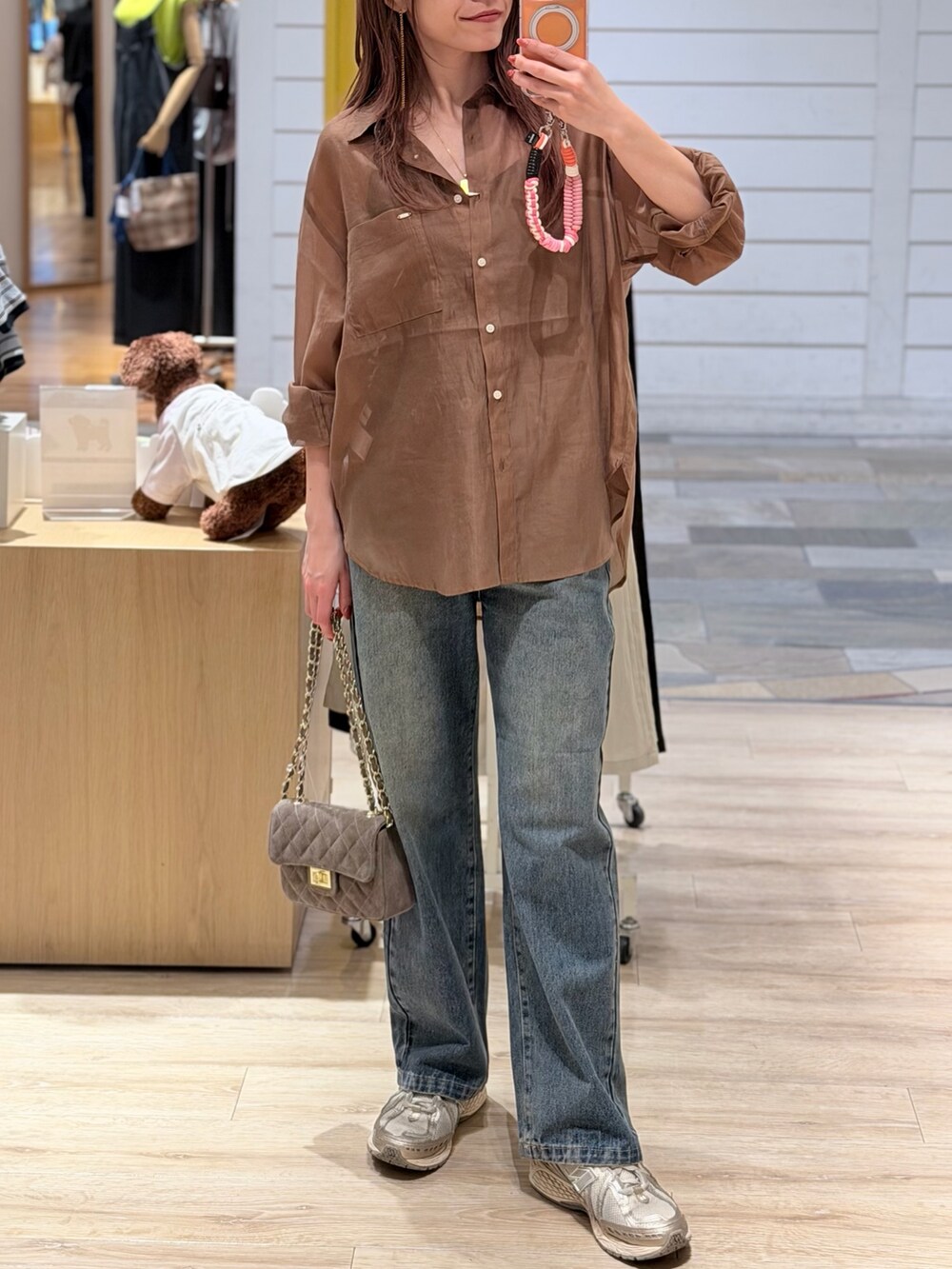 ブラウン系のシャツ/ブラウス、ブルー系のデニムパンツ、ベージュ系のショルダーバッグを着用したレディースの夏コーディネートの2枚目の写真