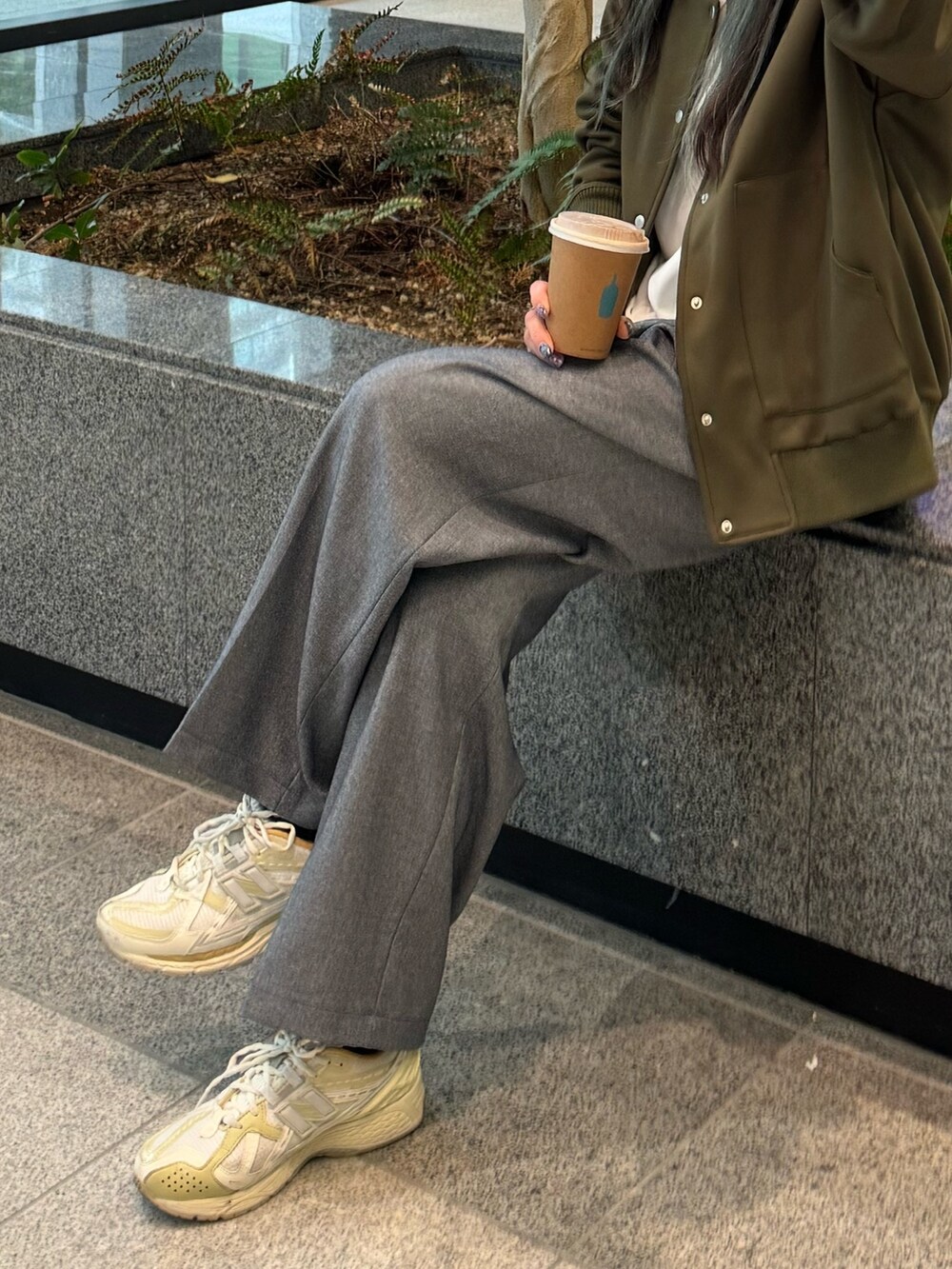 ブルー系のスラックス、グリーン系のブルゾン、ホワイト系のTシャツ/カットソーを着用したレディースの春コーディネートの3枚目の写真