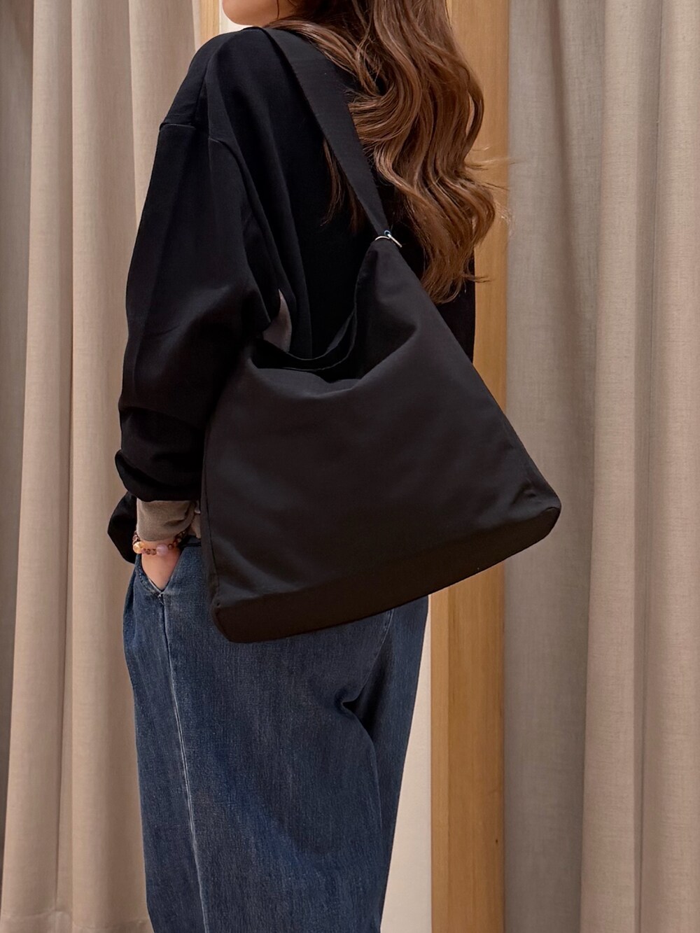 ブラック系のTシャツ/カットソー、ブルー系のデニムパンツ、ブラック系のショルダーバッグを着用したレディースの春コーディネートの3枚目の写真