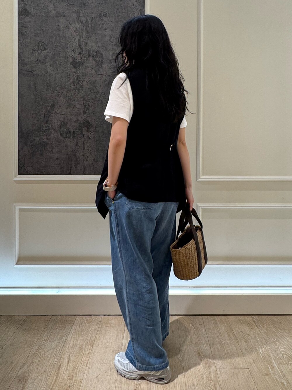 ブルー系のデニムパンツ、ブラック系のベスト、ホワイト系のTシャツ/カットソーを着用したレディースの夏コーディネートの3枚目の写真