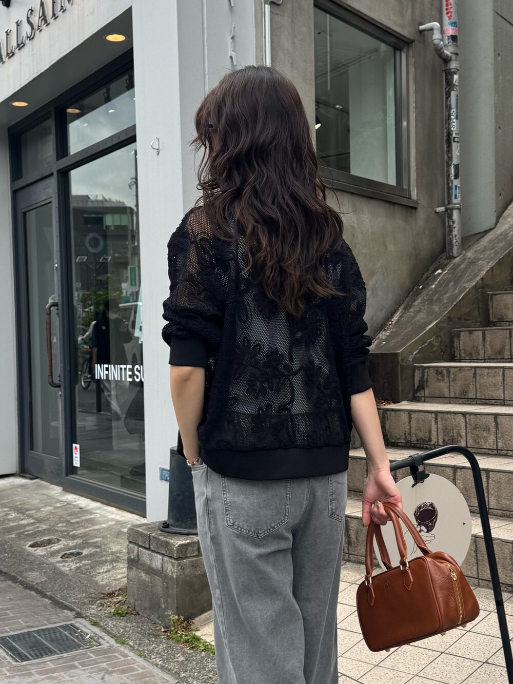 ブラック系のカーディガン/ボレロ、ベージュ系のデニムパンツを着用したレディースの春コーディネートの3枚目の写真