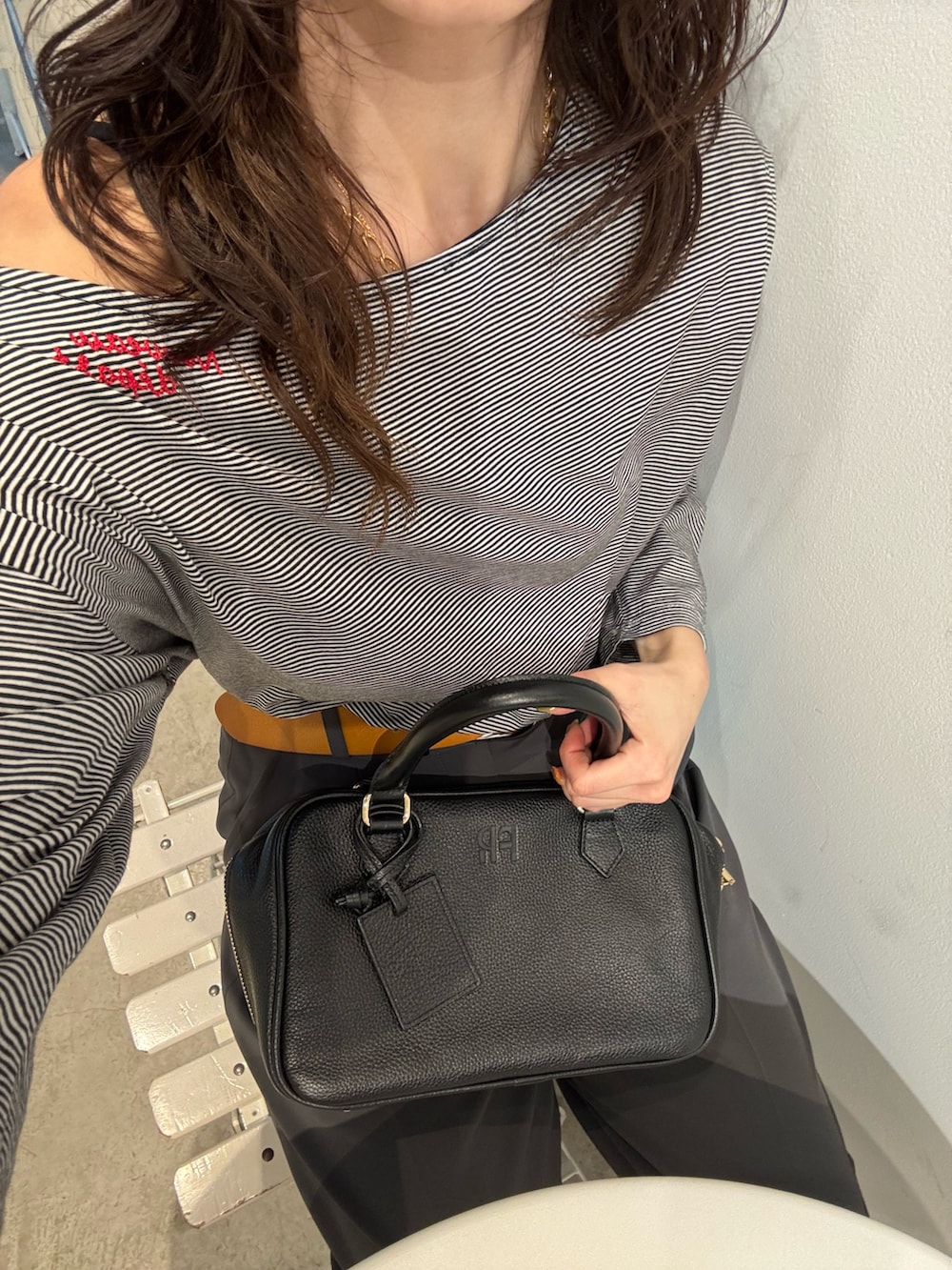 ホワイト系のTシャツ/カットソー、ブラック系のスラックスを着用したレディースの春コーディネートの6枚目の写真