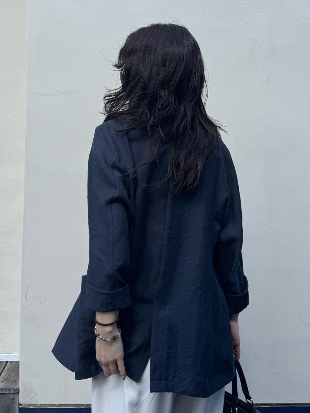 イエロー系のショルダーバッグ、ベージュ系のテーラードジャケット、ベージュ系のその他パンツを着用したレディースの春コーディネートの4枚目の写真