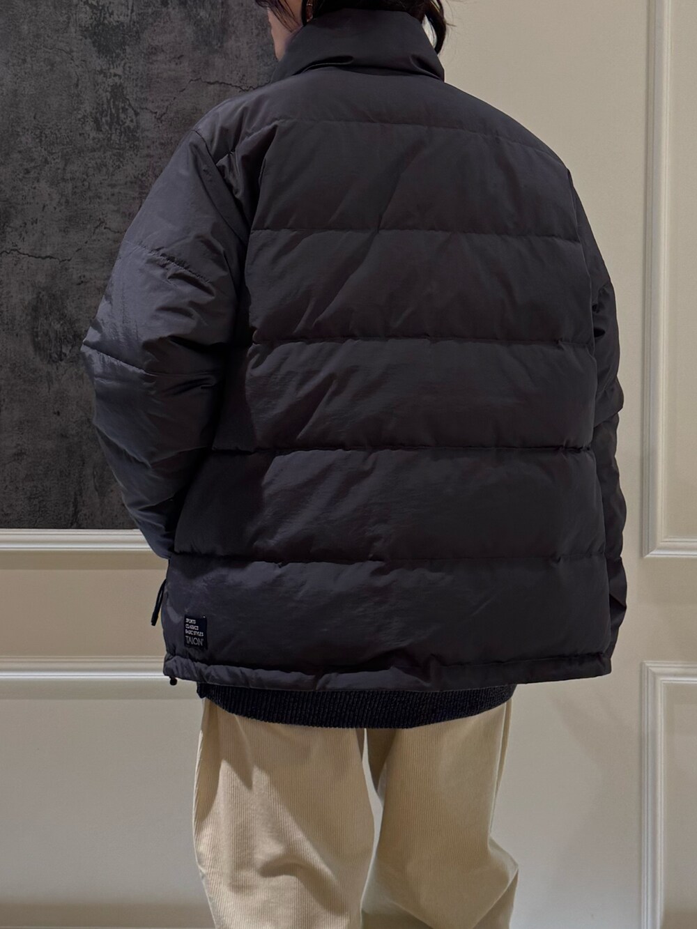 グレー系のダウンジャケット/コート、グレー系のニット/セーター、ブルー系のキャップを着用したレディースの秋コーディネートの4枚目の写真