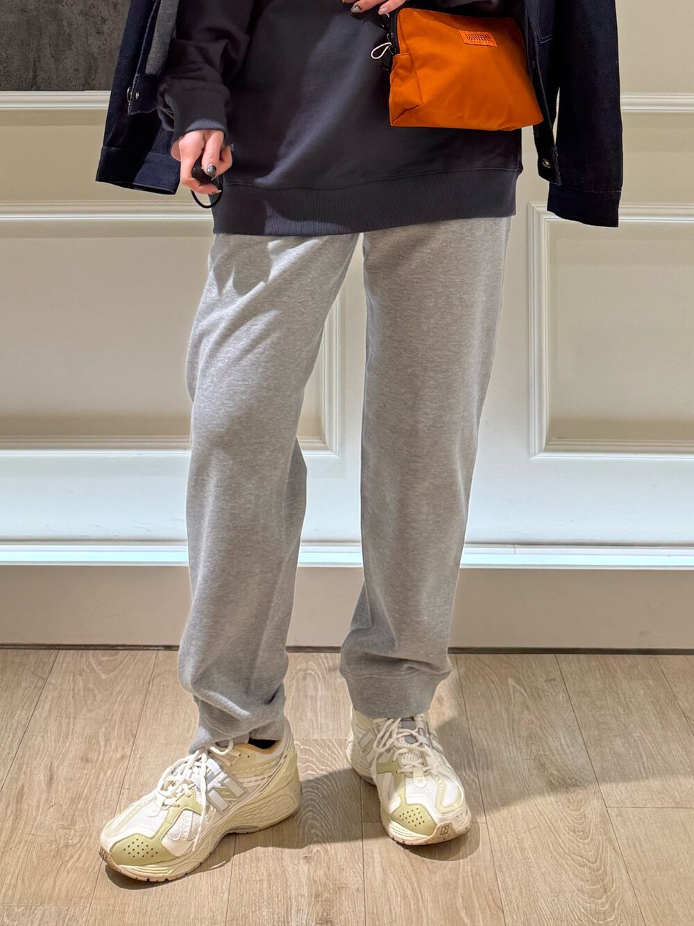 ブルー系のデニムジャケット、グレー系のスウェット、オレンジ系のショルダーバッグを着用したレディースの春コーディネートの3枚目の写真