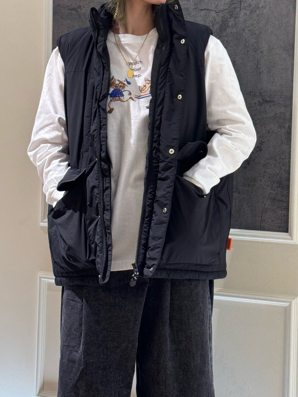 ブラック系のベスト、ホワイト系のTシャツ/カットソー、ブラック系のデニムパンツを着用したレディースの秋コーディネートの2枚目の写真