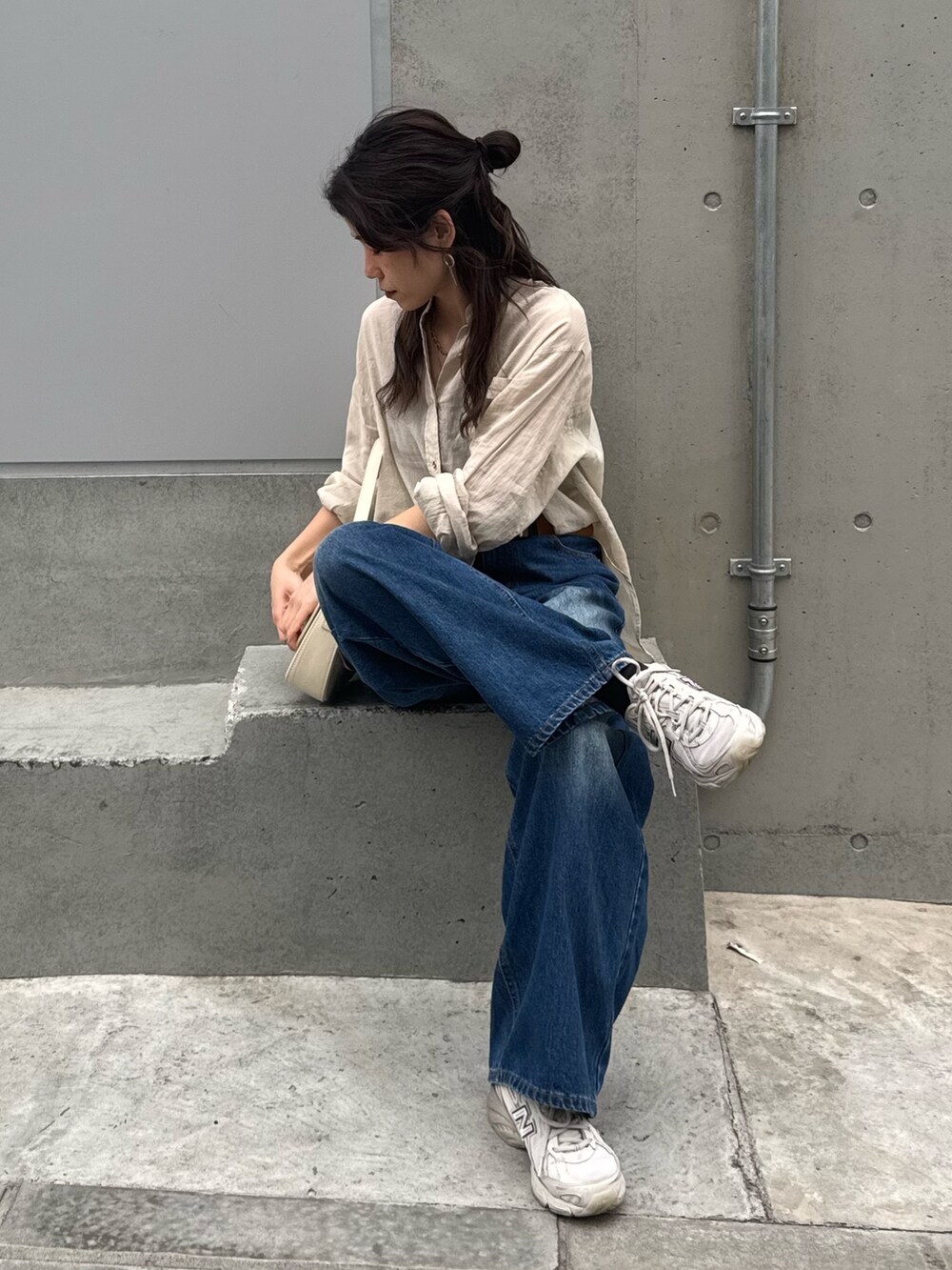 ベージュ系のシャツ/ブラウス、ブルー系のデニムパンツを着用したレディースの春コーディネートの3枚目の写真