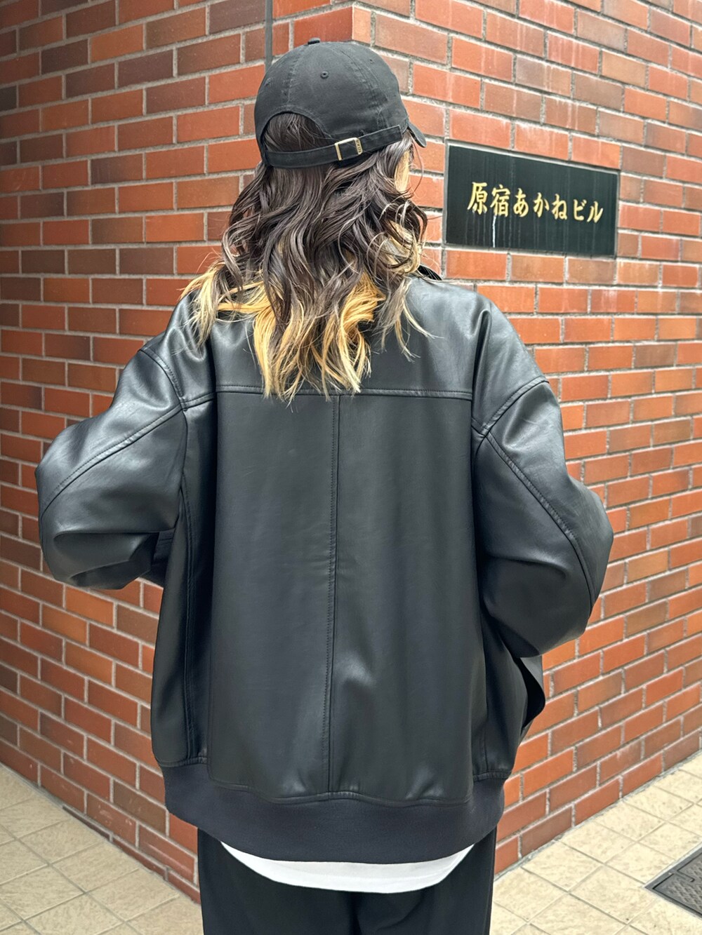 ブラック系のブルゾン、ホワイト系のTシャツ/カットソーを着用したレディースの秋コーディネートの3枚目の写真