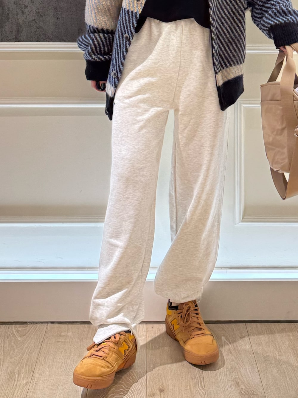 グレー系のカーディガン/ボレロ、グレー系のスウェットパンツ、ベージュ系のショルダーバッグを着用したレディースの秋コーディネートの4枚目の写真