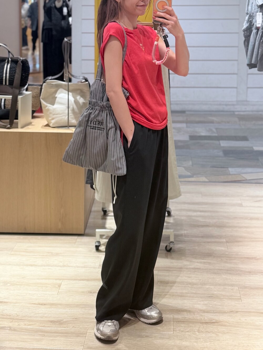 レッド系のTシャツ/カットソー、ブラック系のその他パンツ、ブラック系のトートバッグを着用したレディースの夏コーディネートの4枚目の写真