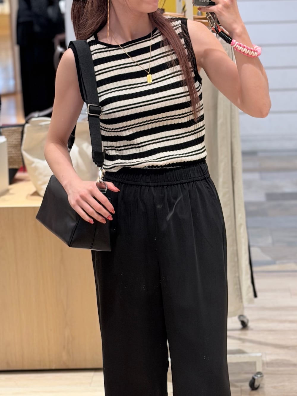 ブルー系のニット/セーター、ブラック系のその他パンツ、ブラック系のショルダーバッグを着用したレディースの夏コーディネートの3枚目の写真