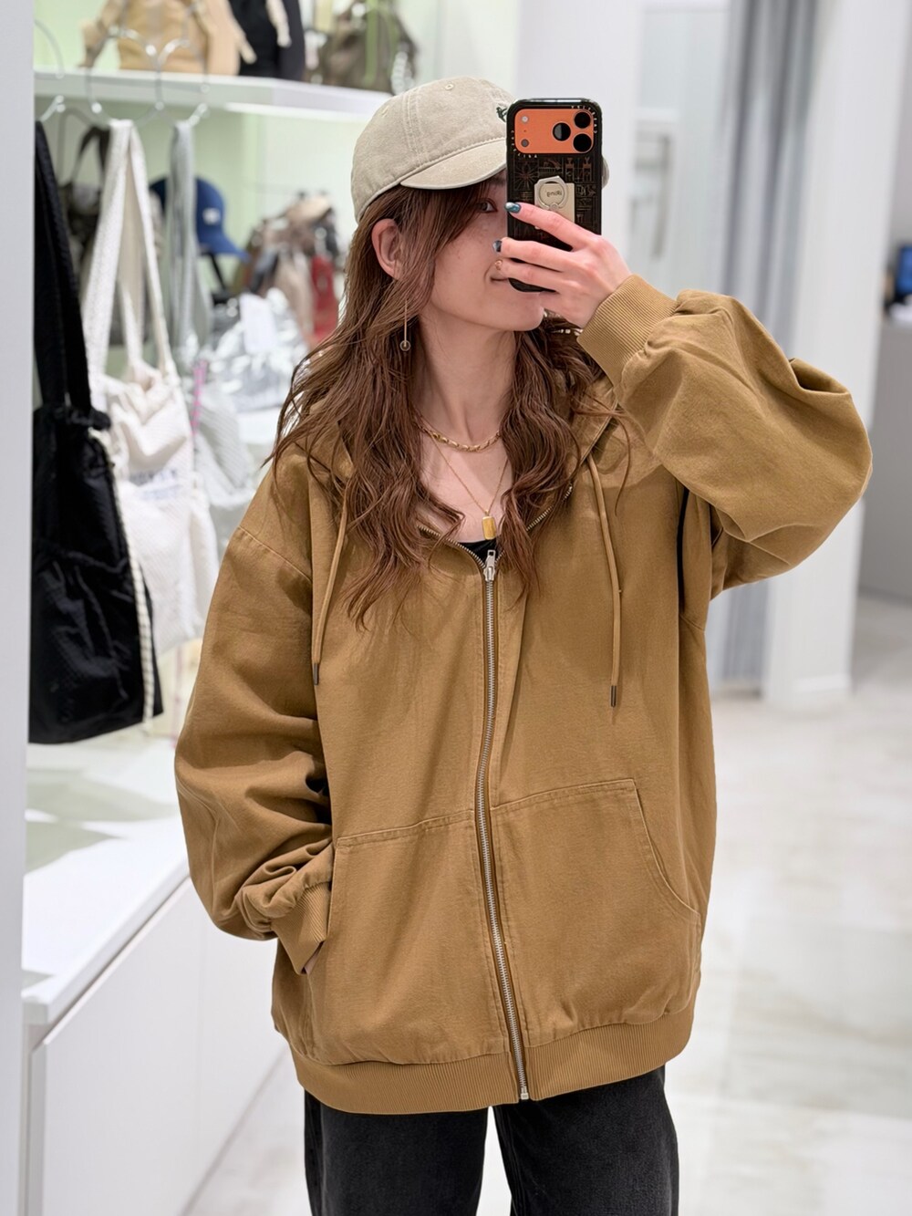 ベージュ系のブルゾン、ブラック系のデニムパンツを着用したレディースの春コーディネートの4枚目の写真