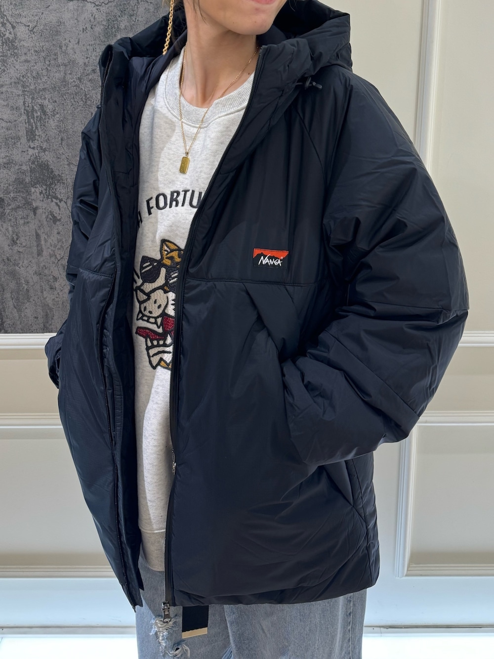 ブラック系のスウェット、ブラック系のダウンジャケット/コート、グリーン系のサンダルを着用したレディースの秋コーディネートの2枚目の写真