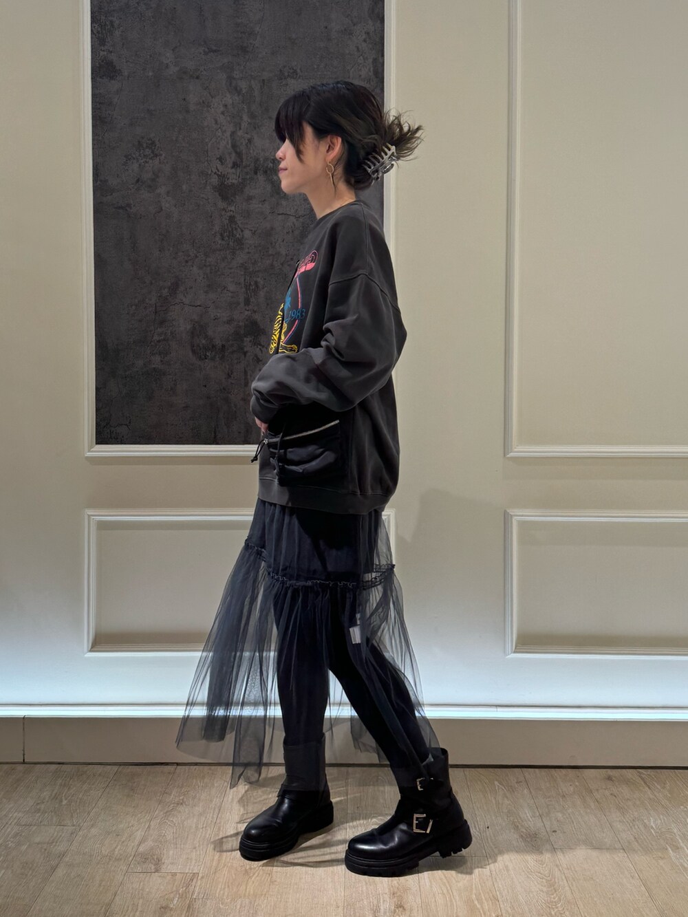 ブラック系のスウェット、グレー系のスカート、ブラック系のブーツを着用したレディースの冬コーディネートの2枚目の写真