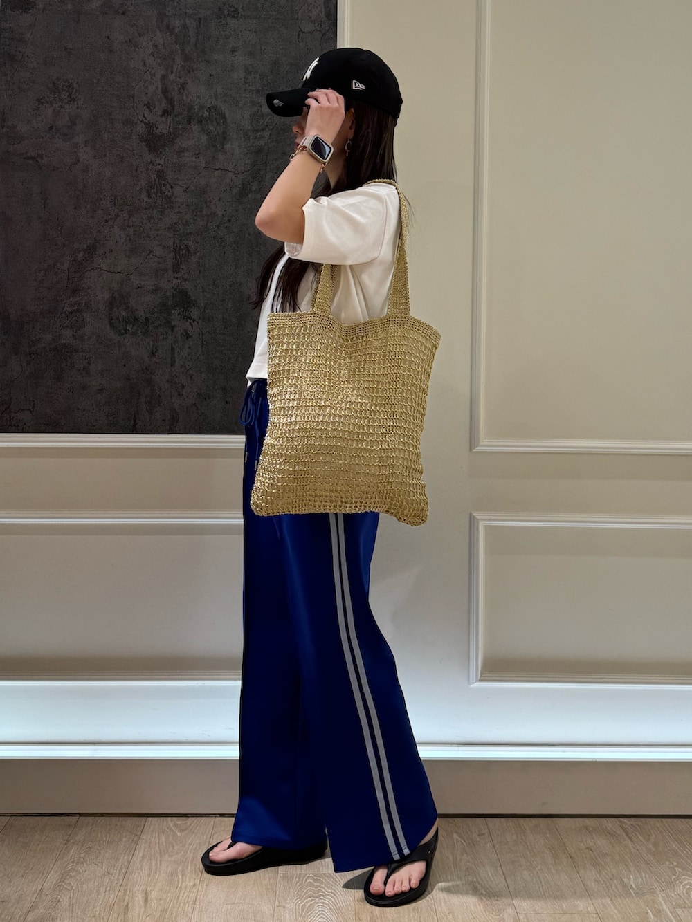 ホワイト系のTシャツ/カットソー、ホワイト系のその他パンツ、ゴールド系のトートバッグを着用したレディースの春コーディネートの2枚目の写真