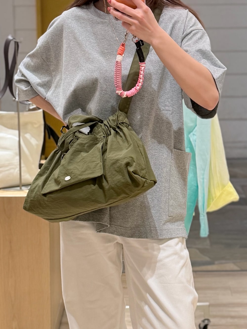 グレー系のTシャツ/カットソー、グリーン系のショルダーバッグを着用したレディースの夏コーディネートの2枚目の写真