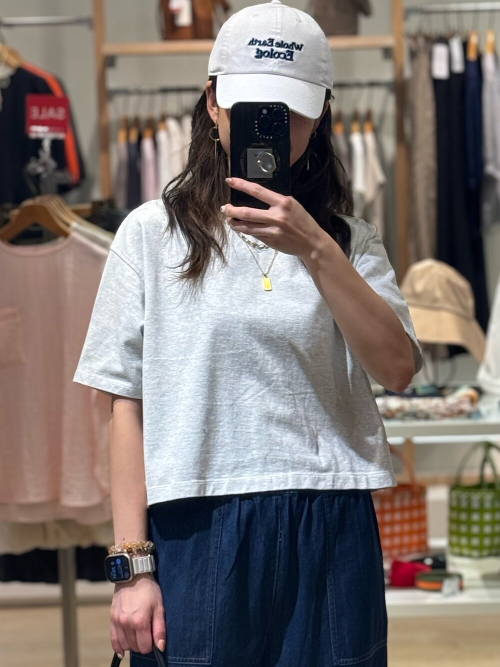グレー系のTシャツ/カットソー、ブルー系のデニムパンツ、ベージュ系のかごバッグを着用したレディースの夏コーディネートの3枚目の写真