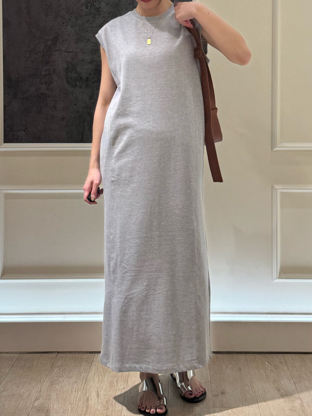 グレー系のワンピース、イエロー系のショルダーバッグ、シルバー系のサンダルを着用したレディースの夏コーディネートの2枚目の写真