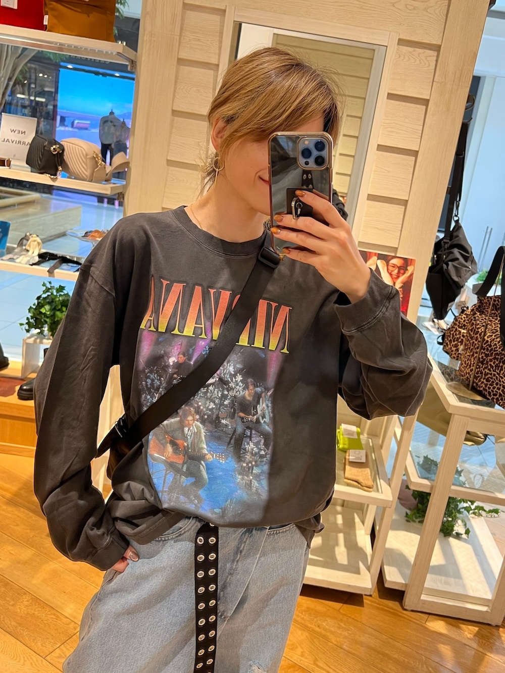 ベージュ系のショルダーバッグ、ブラック系のTシャツ/カットソー、ブルー系のデニムパンツを着用したレディースの秋コーディネートの2枚目の写真