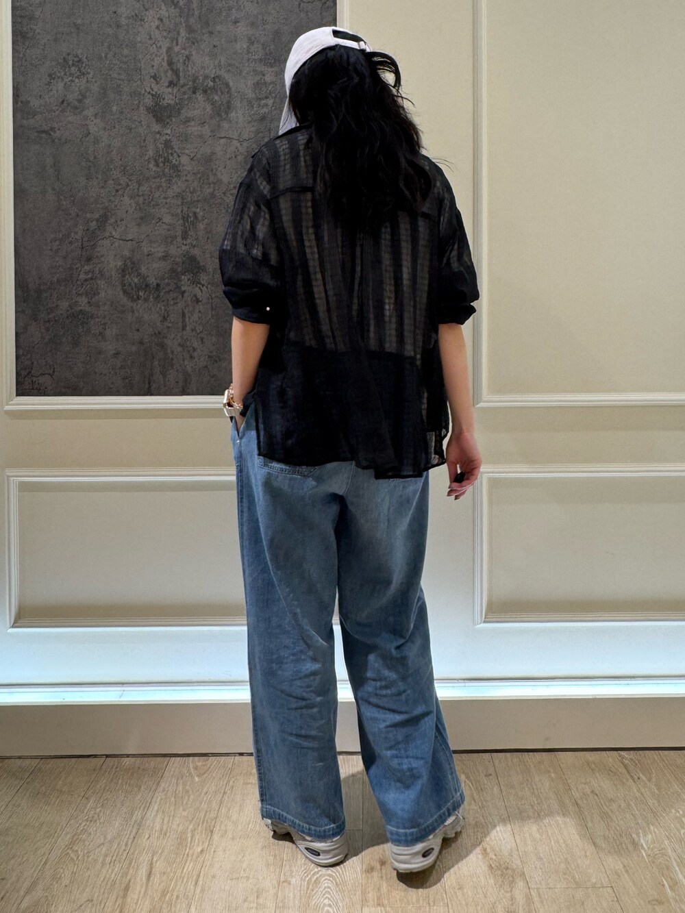 ブラック系のシャツ/ブラウス、ブルー系のデニムパンツ、ホワイト系のキャップを着用したレディースの夏コーディネートの3枚目の写真