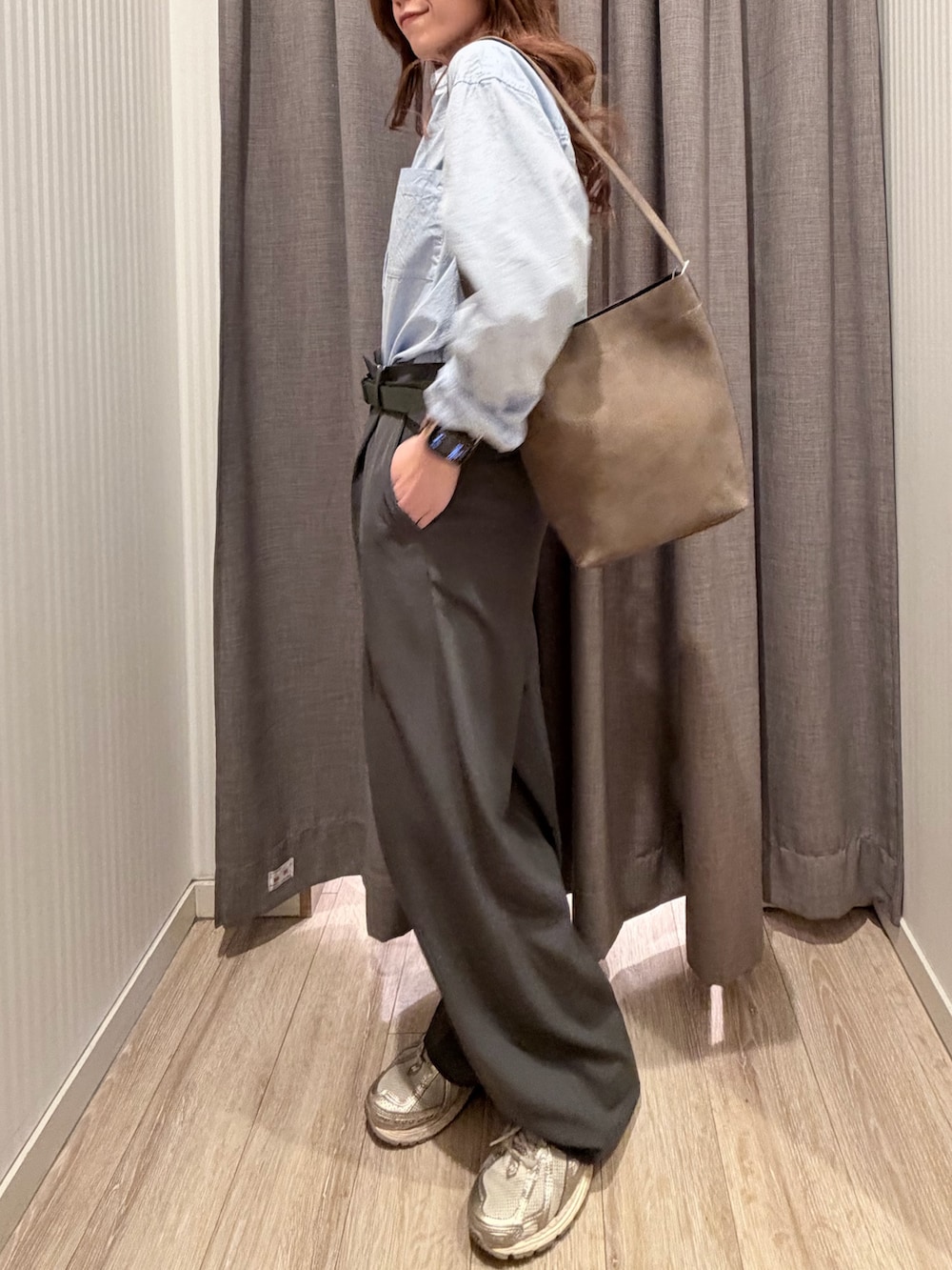 ブルー系のシャツ/ブラウス、ベージュ系のショルダーバッグ、グレー系のスラックスを着用したレディースの春コーディネートの2枚目の写真