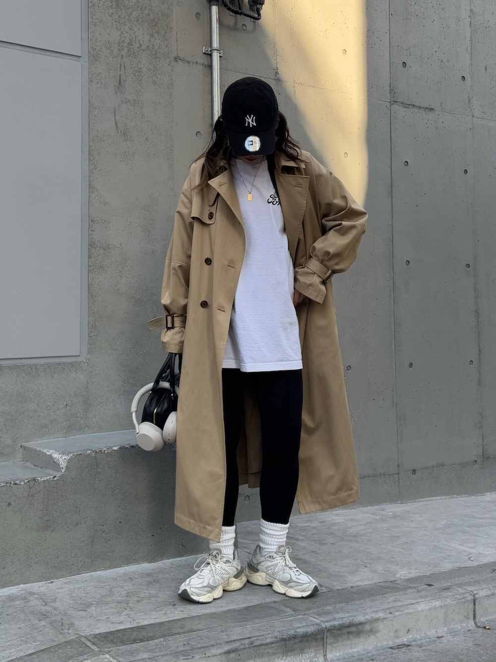 ベージュ系のトレンチコート、ブラック系のハンドバッグを着用したレディースの冬コーディネートの2枚目の写真