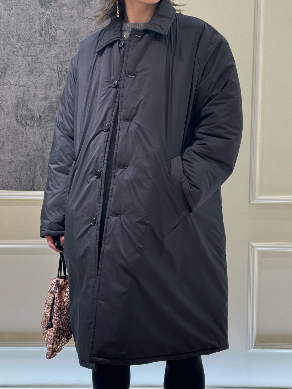 グレー系のステンカラーコート、ブラック系のその他パンツ、ブラック系のブーツを着用したレディースの冬コーディネートの2枚目の写真