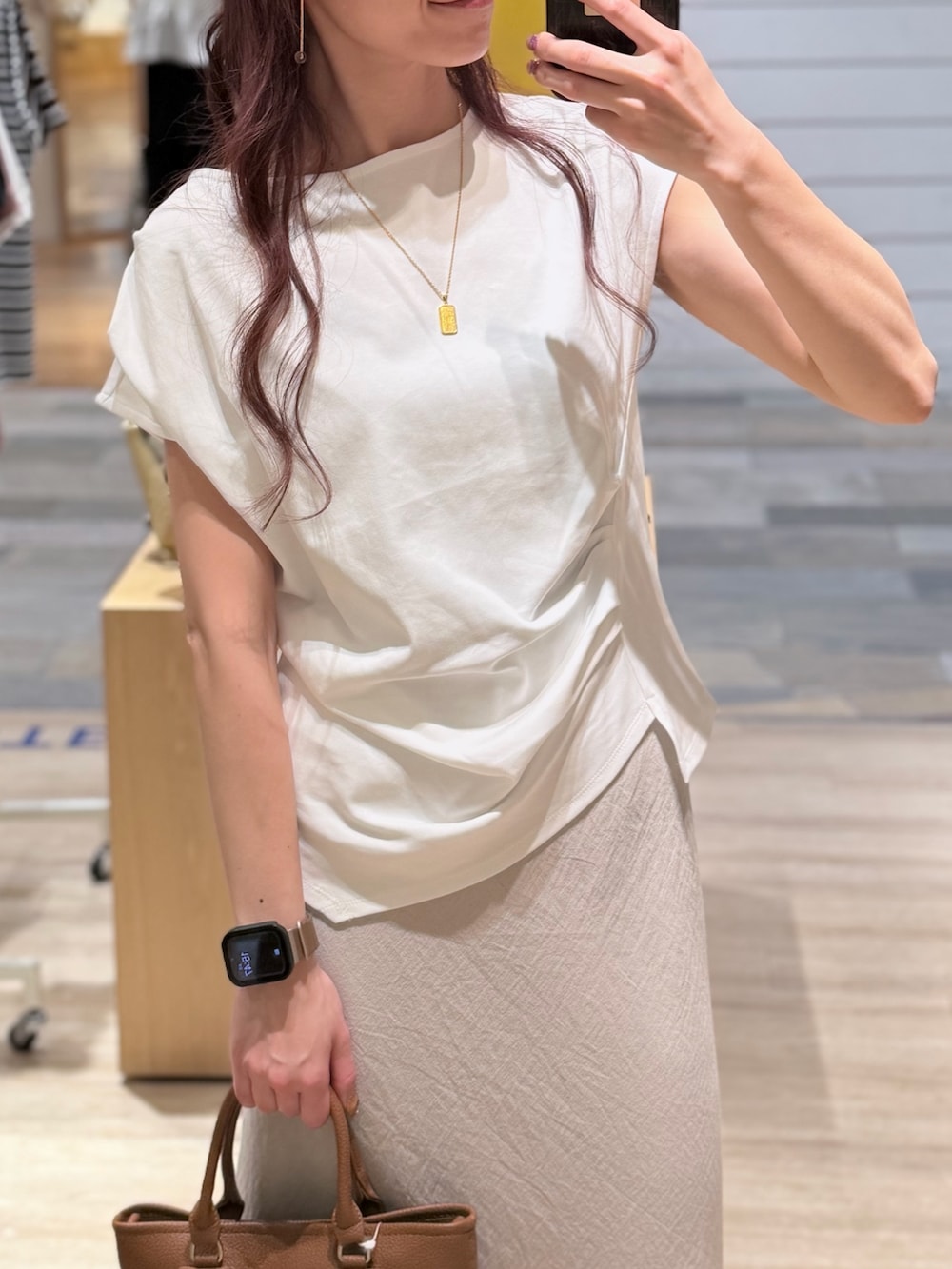 ホワイト系のTシャツ/カットソー、ベージュ系のスカート、ブラウン系のトートバッグを着用したレディースの夏コーディネートの2枚目の写真