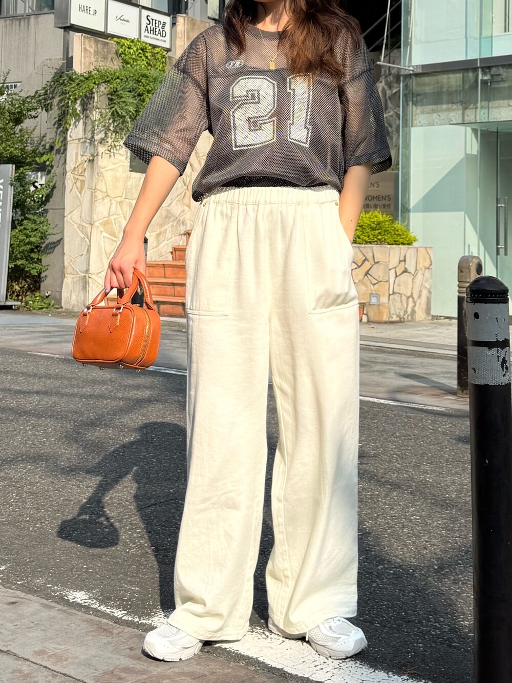 グレー系のTシャツ/カットソー、ブルー系のデニムパンツ、イエロー系のショルダーバッグを着用したレディースの夏コーディネートの6枚目の写真